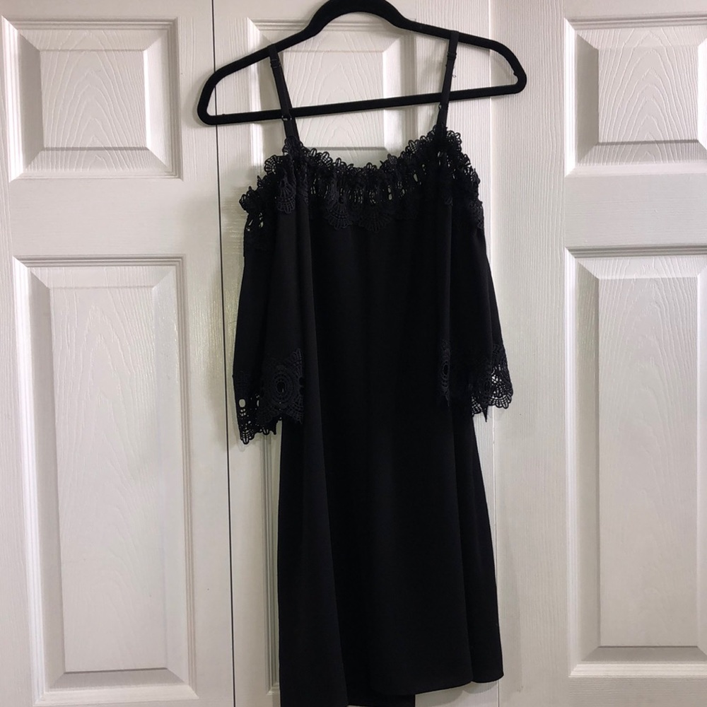 Black dress. Open at the shoulders. Has adjustable straps